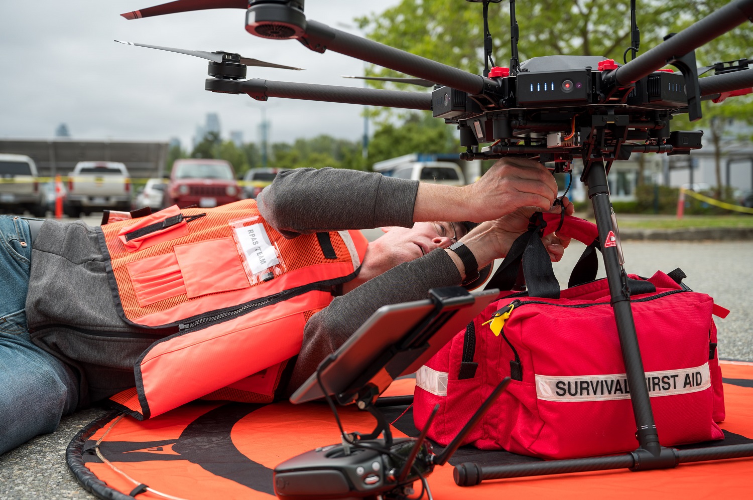Man in safety vest attaching first aid kit to drone