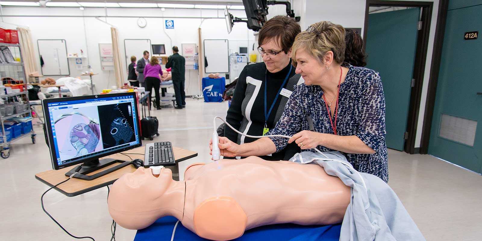 two female clinical preceptors working with simulation manikin
