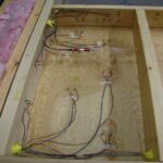 Wood-frame test panel lying on floor with sensor cables attached