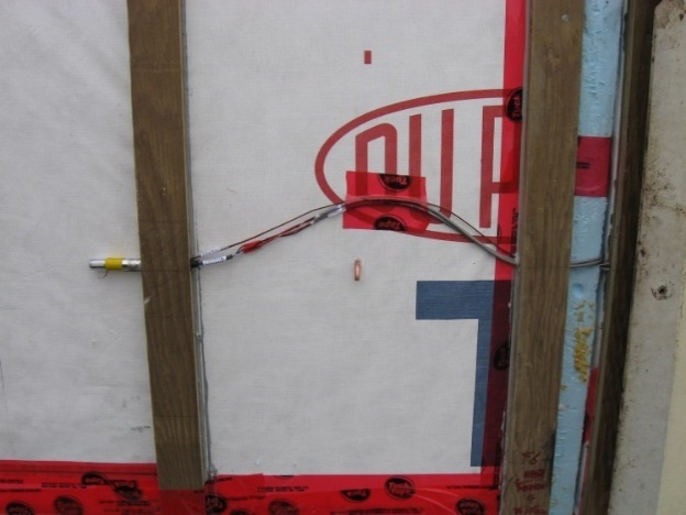 Exterior side of test panel showing weather barrier and wood strapping with sensor cables attached