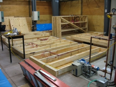 Several wood-frame test panels being assembled on the ground