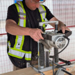 A MaTT Hub student operates a precision dowel-drilling machine on a mass timber connection block during the on-site practicum.