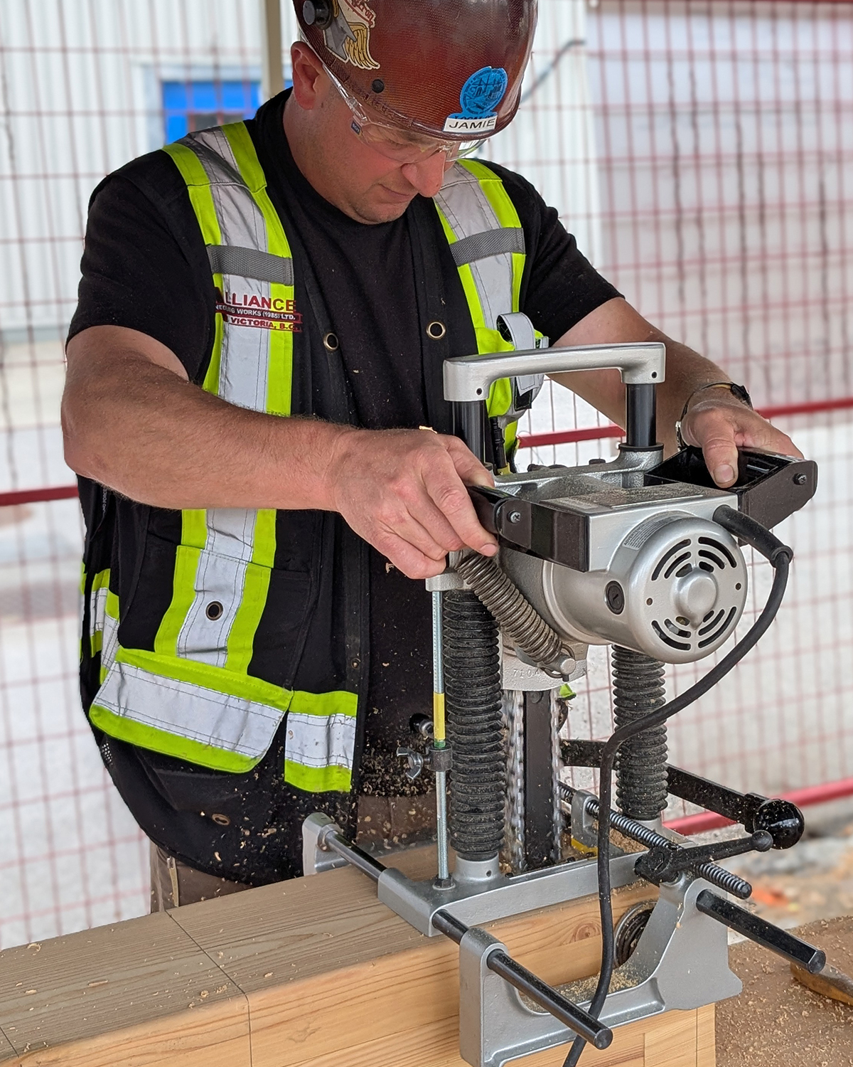 A MaTT Hub student operates a precision dowel-drilling machine on a mass timber connection block during the on-site practicum.