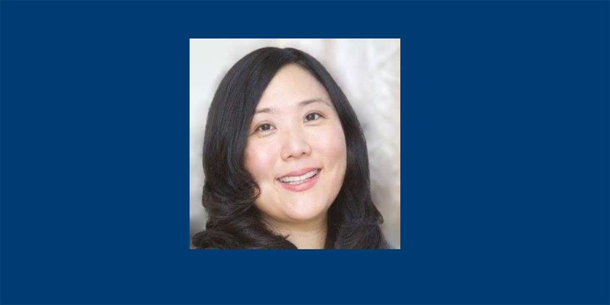 Jennifer Madigan with black hair on a blue background