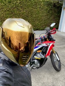 Amanda with her motorcycle and helmet.