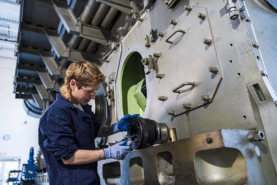 BCIT Marine Engineering alumna Ana Cross working on ship machinery.