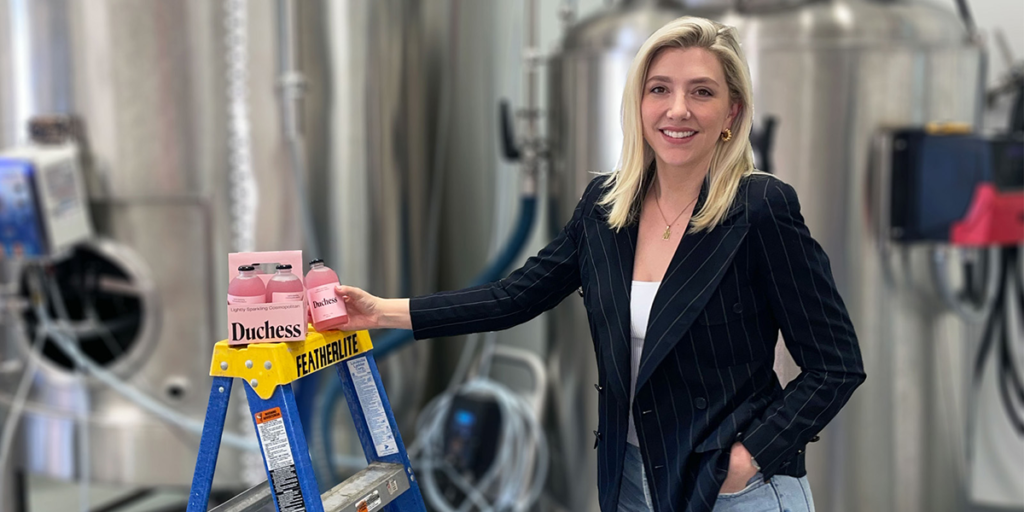 BCIT alum Olivia Lovenmark smiles in production facility holding Duchess Cocktails