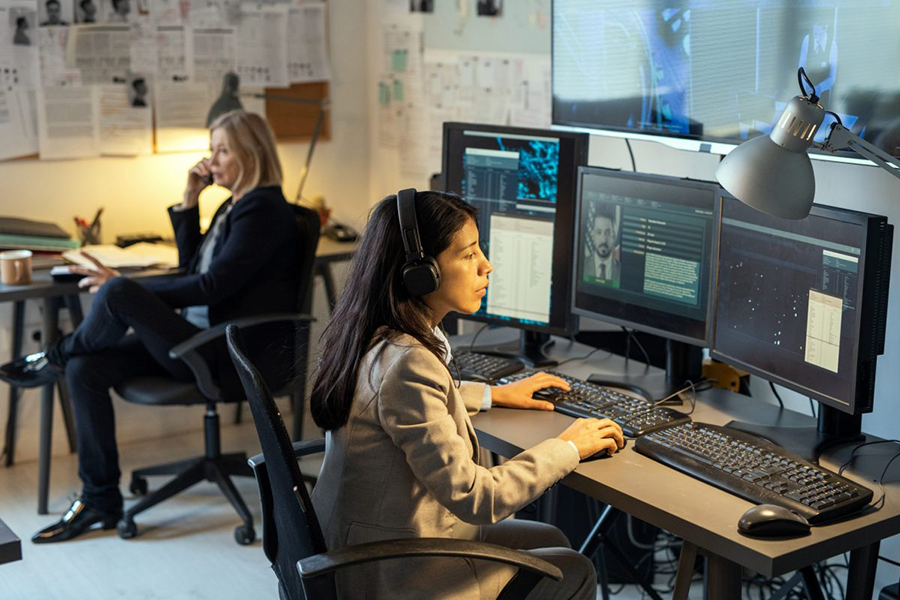 Serious agents of intelligence service sitting in front of computer monitors