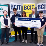 Five people standing in from of three BCIT banners holding a novelty cheque