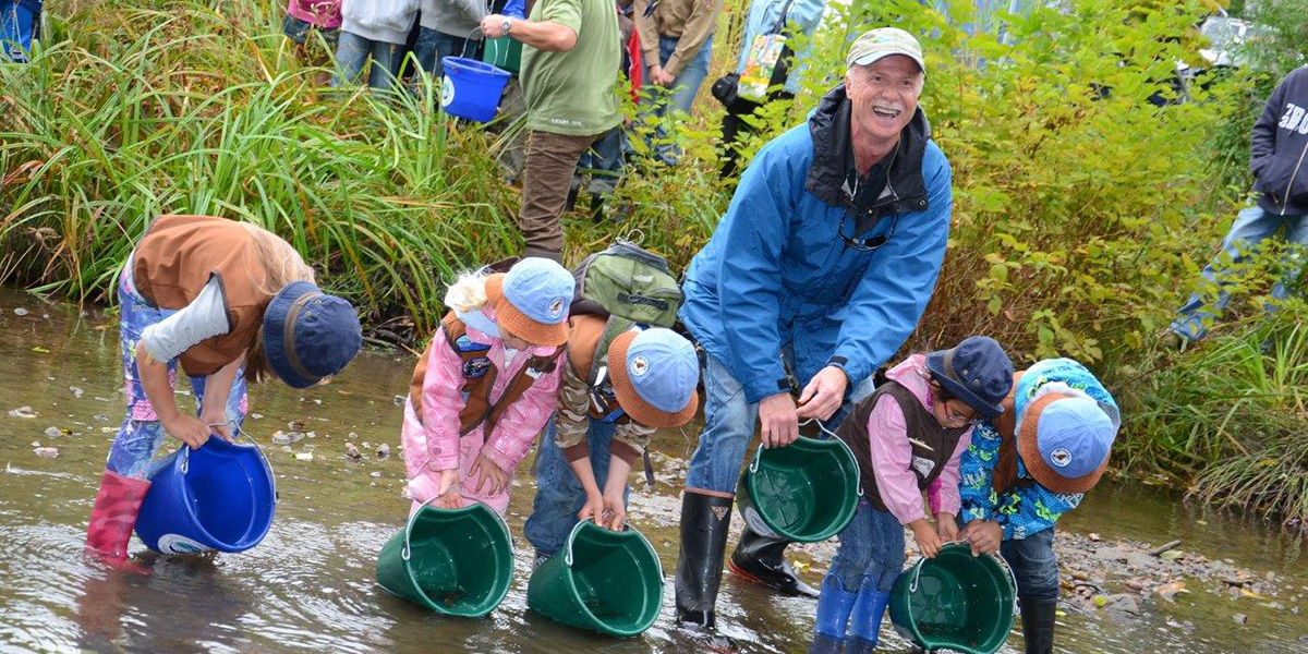 Mark Angelo with kids releasing fish in Guichon