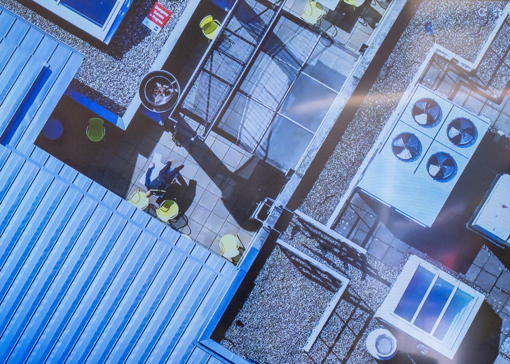 Aerial image of roof of building with body lying flat on back