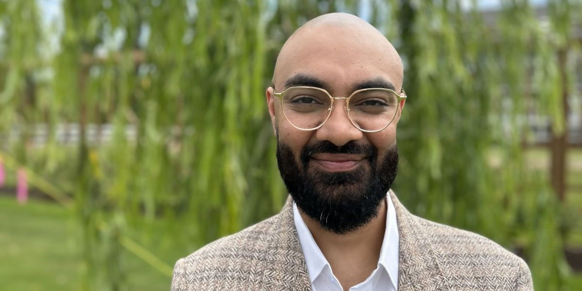 Prabhjot Lalli stands in front of a willow tree