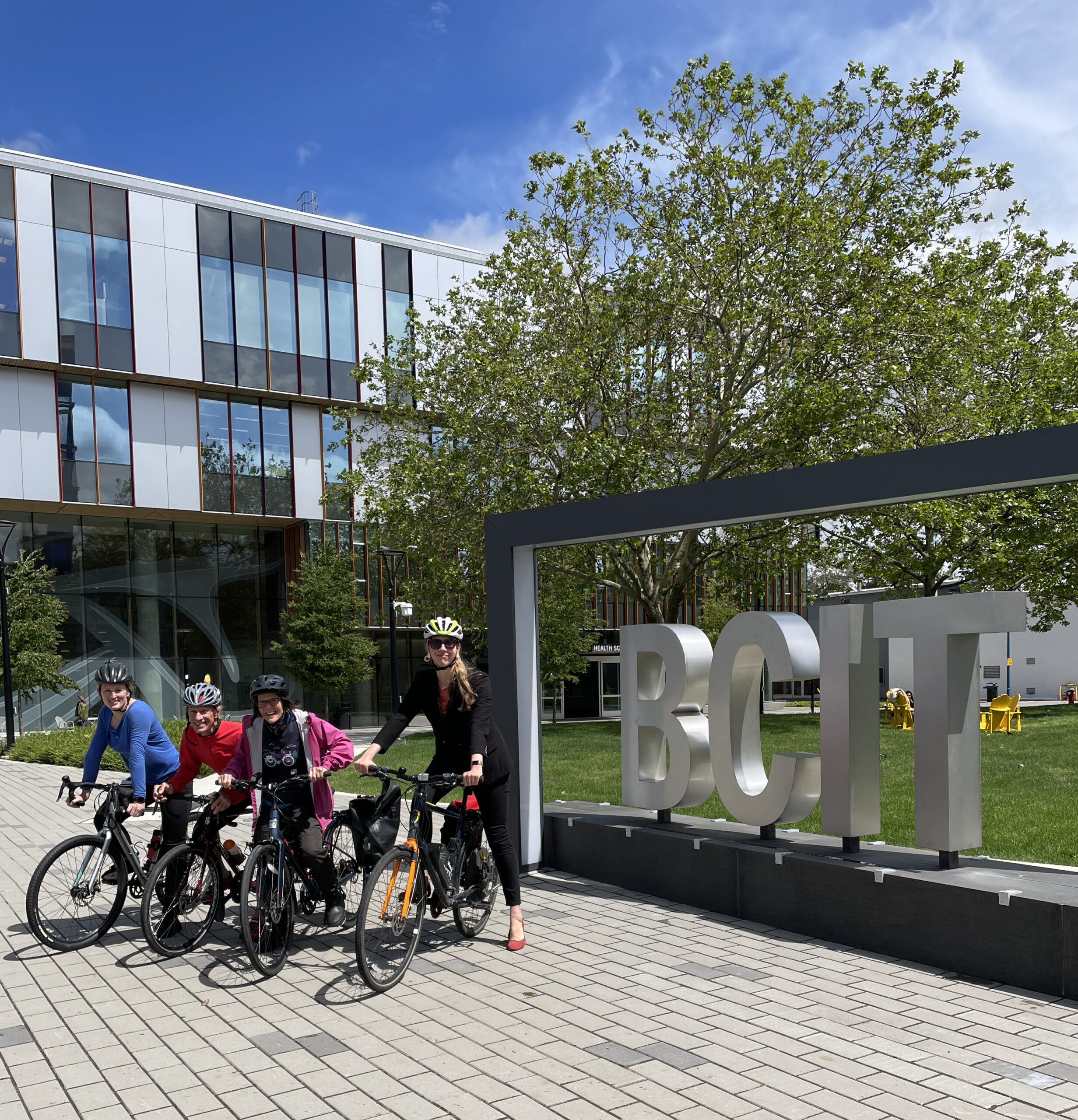 Bike team in front of the BCIT letters at the BCIT Burnaby Campus