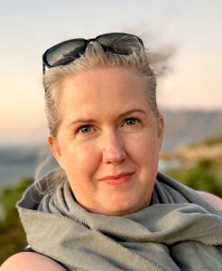 woman wearing sunglasses on her head against a sunset background