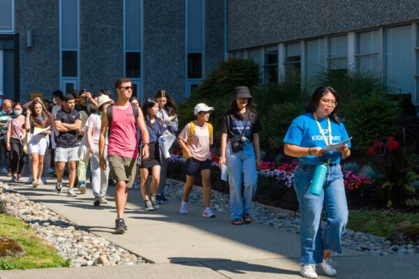 Tour guide leads group of new students on a campus tour during campus orientation.