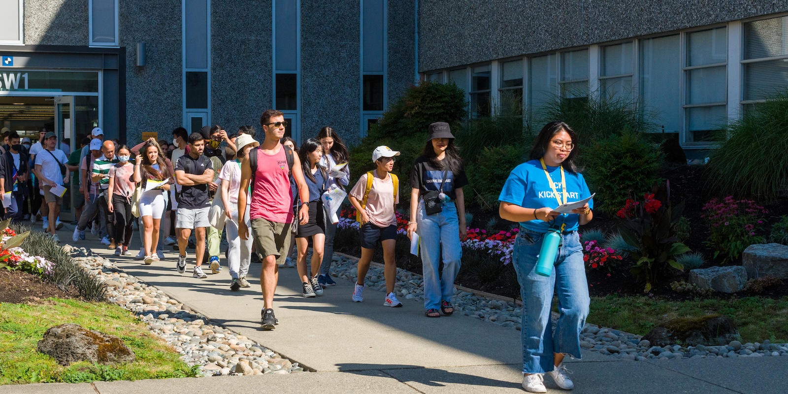 Tour guide leads group of new students on a campus tour during campus orientation.