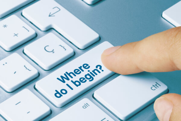 laptop with finger pointing to key that says where do I begin?