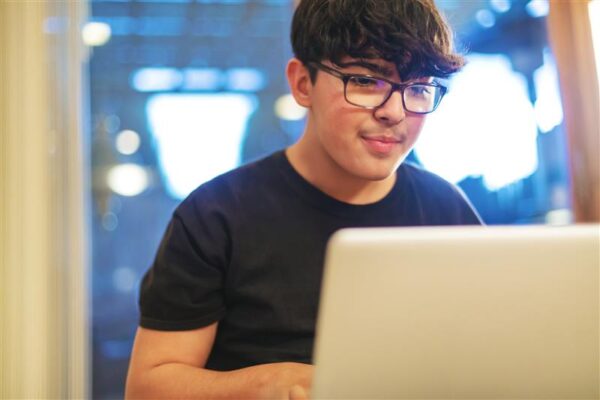 adolescent teen studying on their laptop remotely