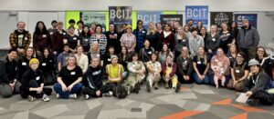 A group of women and gender-diverse electricians and allies pose for a picture