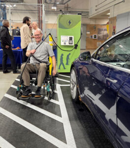 person in wheelchair using mock ev charger