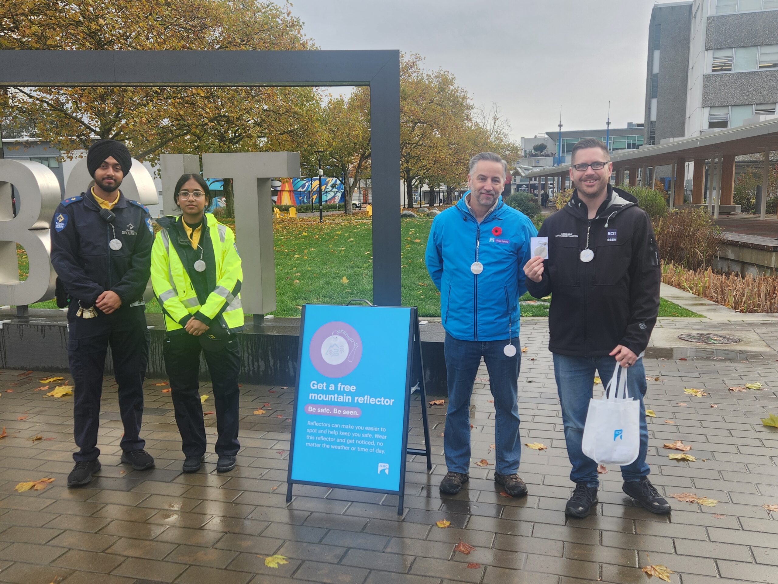Aaron with colleagues handing out mountain reflectors at Beedie Plaza.