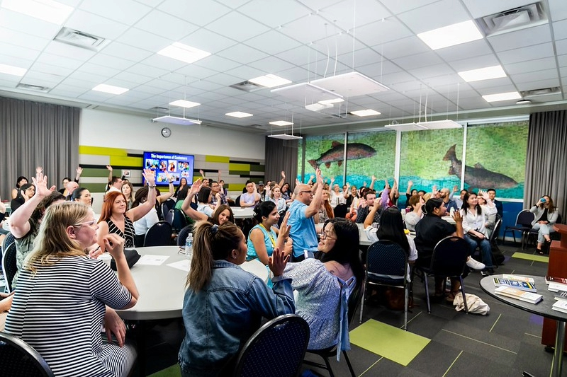 employees raising their hands in the room