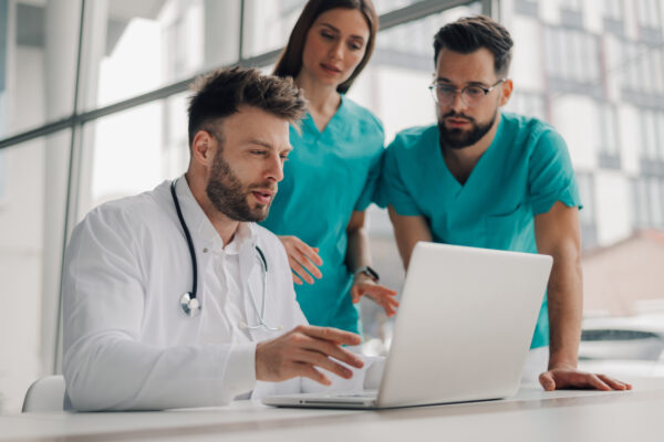 Medical team analyzing patient data on laptop in hospital