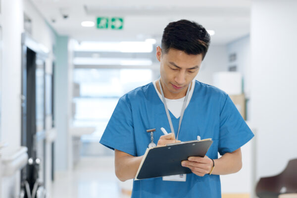 Doctor, planning and writing in documents, medical checklist or charts for hospital notes or clinic service. Healthcare worker, asian man or nurse smile for clipboard, paperwork or thinking in clinic