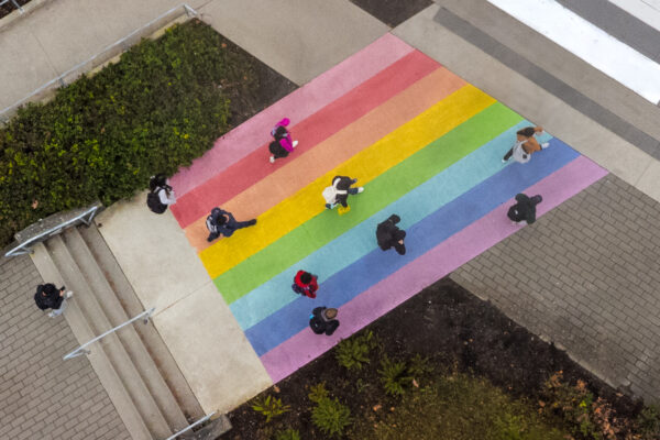 Top-down photo of rainbow crosswalk on the BCIT Burnaby campus leading to SW1.