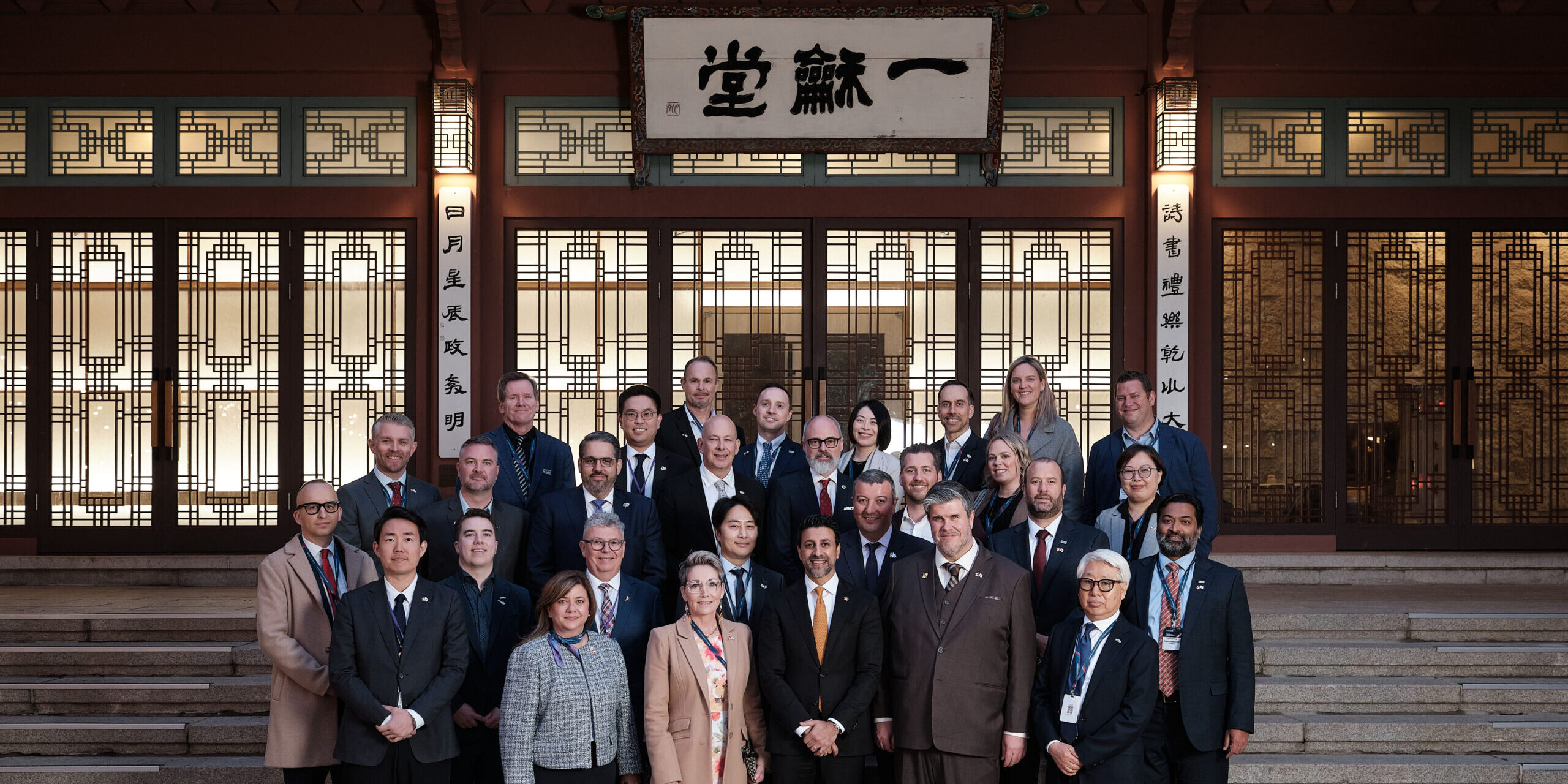 A group of people take a group photo in front of a national building in South Korea