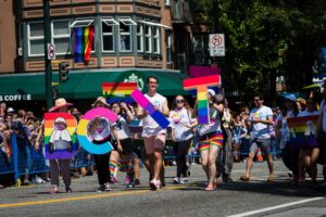 BCIT marching in Vancouver Pride Parade in 2019, with four people holding colourful letters of BCIT.