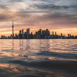 A view of a city skyline, Toronto's, with the CN tower on the left and Lake Ontario in the front.