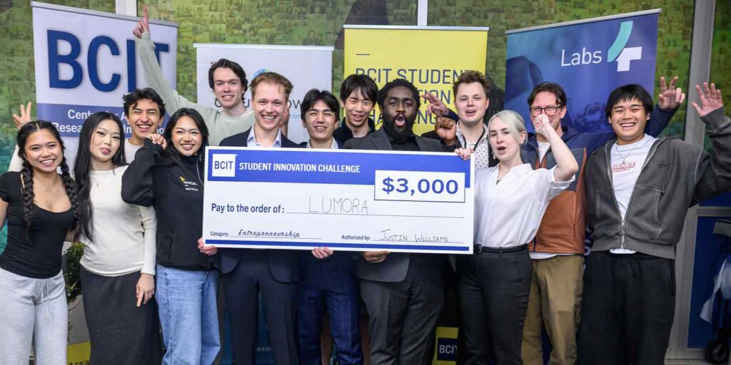 group of studetns smiling holding a big cheque