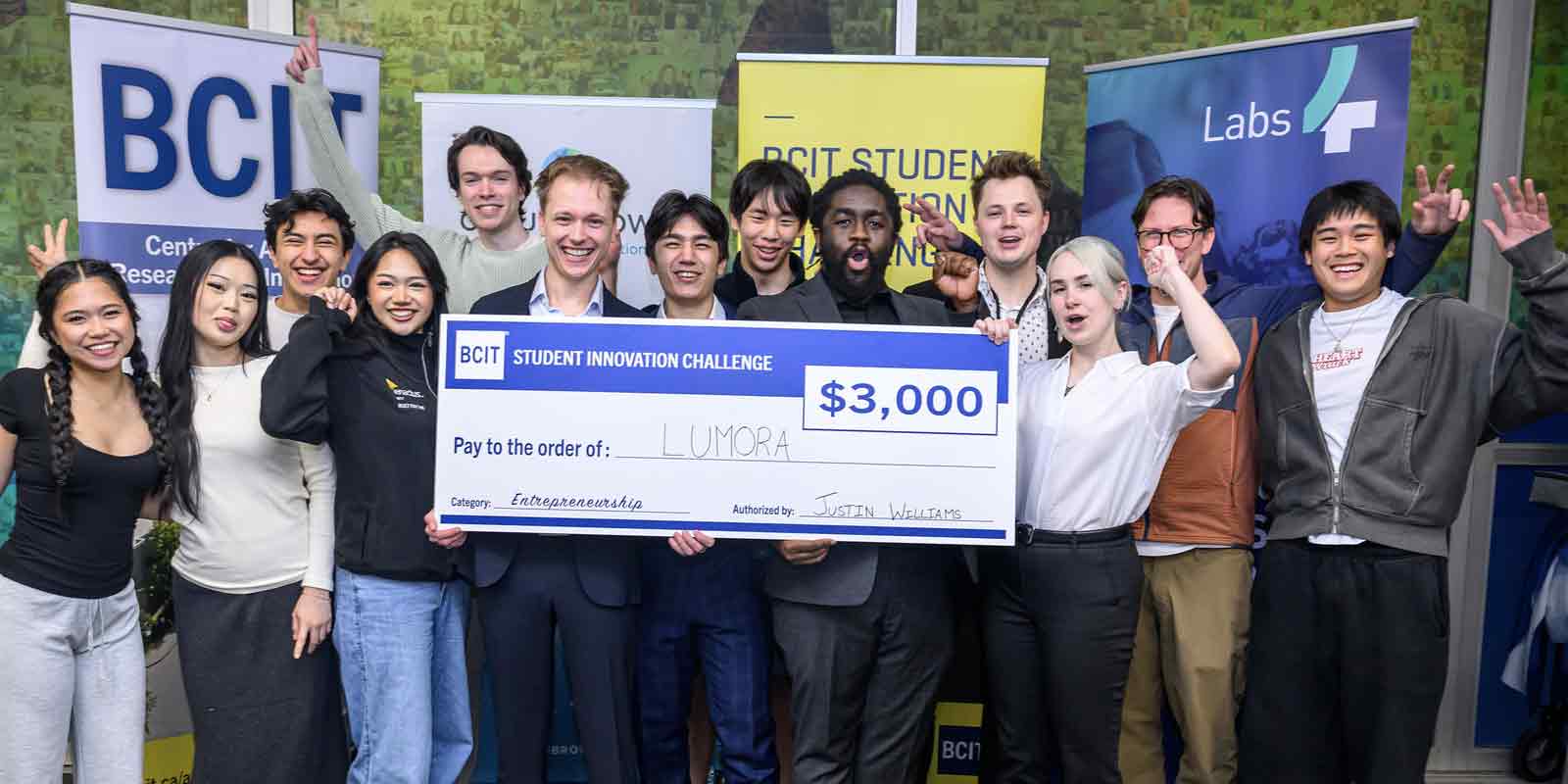 group of studetns smiling holding a big cheque