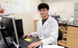 student sitting in front of a monitor in a lab
