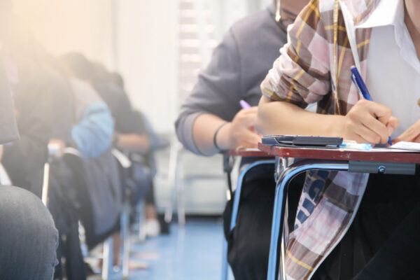 student holding pen writing examination