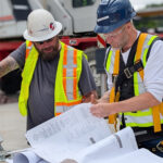 Participants reviewing construction drawings together on the practicum site.