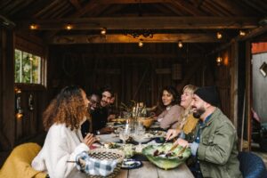 A group of people sitting around a table eating and laughing.