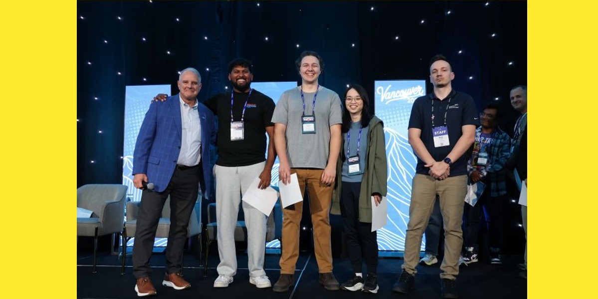 Winning student team is presented certificates on stage by event hosts at aviation cyber competition