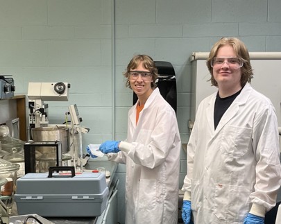 BCIT students Chase Milligan and Oliver Gray in a lab setting smiling to the camera